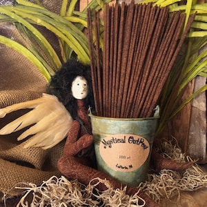 May include: A metal bucket filled with 100 brown incense sticks. The bucket has a white label that says "Mystical Outpost" and "100 ct LaPorte, IN".