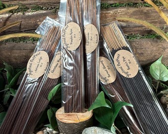 May include: Multiple packs of incense sticks in clear packaging. The incense sticks are various shades of brown and black. Each pack has a brown oval label with the text "Mystical Outpost" and a scent name such as "Autumn Ledge" or "Santa's Pipe."
