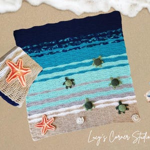 Peut inclure: Une couverture de plage en crochet avec un motif ray&eacute; bleu, vert et blanc. La couverture pr&eacute;sente une vari&eacute;t&eacute; d'applications sur le th&egrave;me de la mer, notamment des &eacute;toiles de mer et des tortues de mer. La couverture est pos&eacute;e sur une surface sablonneuse avec une vague d'&eacute;cume en arri&egrave;re-plan. Le texte "Lucy's Corner Studio" est visible dans le coin inf&eacute;rieur droit de l'image.
