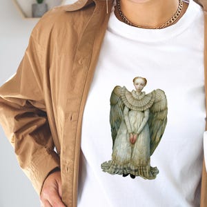Model wearing a white tee with a large angel transfer, wearable craft example for printable Christmas angel paper dolls DIY