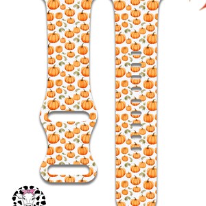 May include: White Apple Watch band with a pattern of orange pumpkins and green leaves.