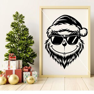 K&ouml;nnte beinhalten: Schwarzwei&szlig;-Illustration eines Grinchs mit Sonnenbrille und Weihnachtsmannm&uuml;tze. Der Grinch l&auml;chelt und hat ein pelziges Gesicht.