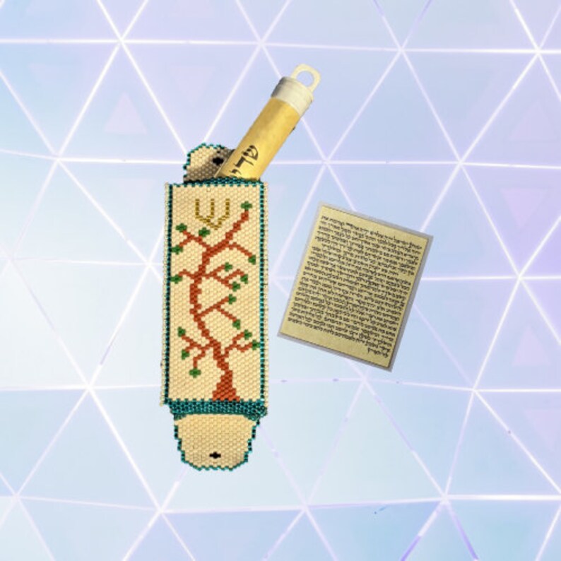 K&ouml;nnte beinhalten: Ein wei&szlig;es, perlenbesetztes Etui mit einem Lebensbaum-Motiv in Braun, Gr&uuml;n und Gold. Das Etui enth&auml;lt eine kleine Schriftrolle, die im Inneren sichtbar ist. Die Schriftrolle ist aus Pergament und tr&auml;gt hebr&auml;ische Schrift. Das Etui ist ein traditionelles j&uuml;disches Gebetszubeh&ouml;r.