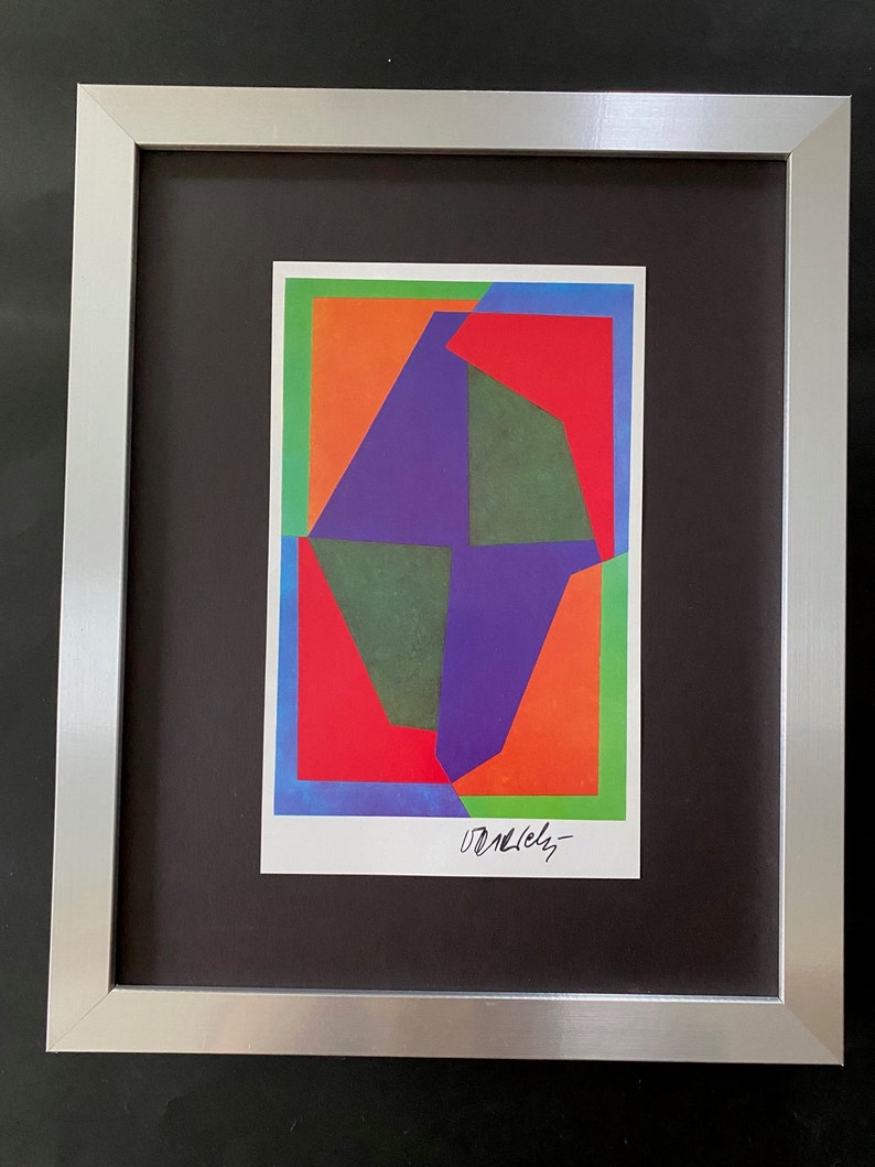 May include: A framed abstract art print featuring geometric shapes in shades of green, red, orange, and purple. The print is signed "Donlevy" in the bottom right corner.