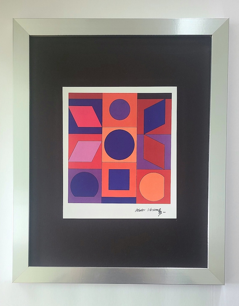 Puede incluir: Una impresi&oacute;n geom&eacute;trica abstracta enmarcada con un dise&ntilde;o colorido de formas rojas, naranjas, moradas y azules. La impresi&oacute;n est&aacute; firmada "Victor Vasarely".