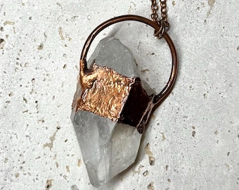 Punta de cristal de cuarzo grande engastada en cobre puro con textura rústica.