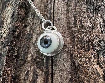 Realistiskt hänge i sterlingsilver med blått glasöga