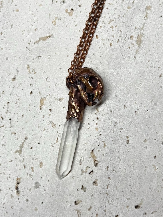 A cat skull sculpted and electroformed in copper with a quartz crystal — dark, detailed, and unapologetically weird in the best way.