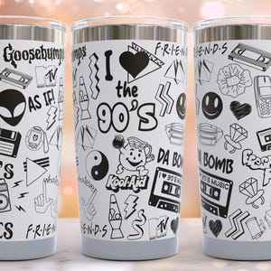 May include: Three stainless steel tumblers with a white background and black 90s themed graphics. The graphics include the words "I love the 90's", "Goosebumps", "90's Vibes", "Fresh Prince", "Da Bomb", "Kool-Aid", and "As If!"