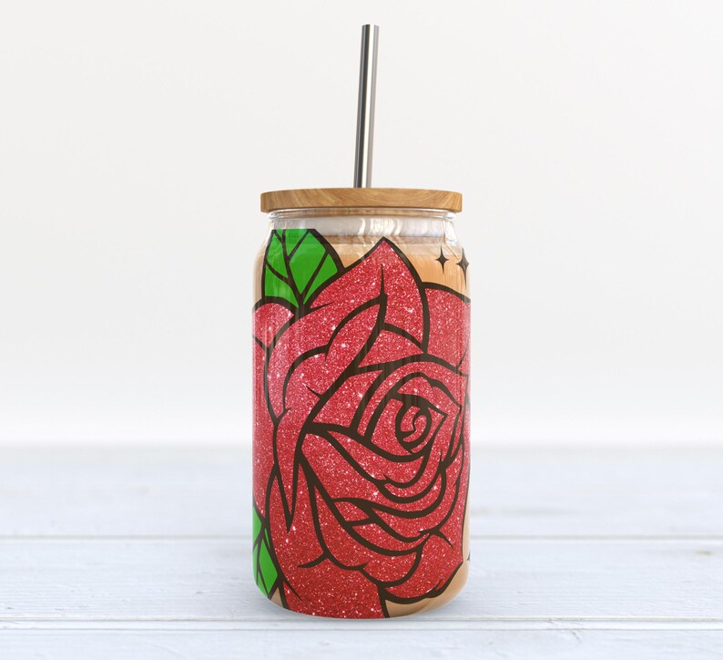 May include: A stainless steel tumbler with a wooden lid and a straw. The tumbler has a red glitter rose design with green leaves.