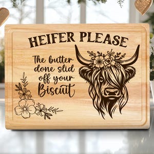 Puede incluir: Tabla de cortar rectangular de madera con borde decorativo. Presenta el texto "HEIFER PLEASE" y un gráfico de una vaca de las Tierras Altas con detalles florales. También incluye la frase "The butter done slid off your Biscuit".
