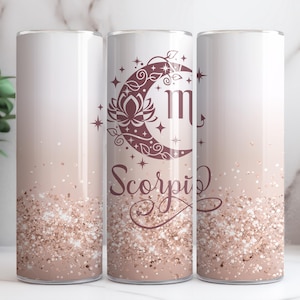 May include: Three stainless steel tumblers with a pink and white ombre glitter design. The tumblers feature a crescent moon with a flower and the zodiac symbol for Scorpio. The text "Scorpio" is written in a cursive font.