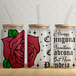 May include: Three frosted glass tumblers with straws. The tumblers have a white background with black text and a red glitter rose design. The text on the tumblers reads "Always Chingona Sometimes Cabrona But Never Pendeja".