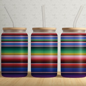 Könnte beinhalten: Drei farbige, gestreifte Glasbecher mit Deckel und Strohhalmen. Die Becher haben ein Muster aus roten, blauen, grünen, gelben und violetten Streifen.