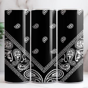 May include: Three black and white patterned tumblers with a bandana design. The tumblers are made of stainless steel and have a black background with a white bandana pattern.