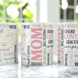May include: Three white ceramic mugs with pink and gold text, including "MOM", "Brave", "Loved", and "Wise". The mugs feature a floral design and are suitable for hot drinks.