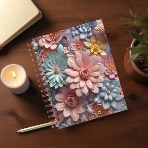 May include: A spiral bound notebook with a colorful floral design. The cover features pink, blue, and yellow paper flowers.
