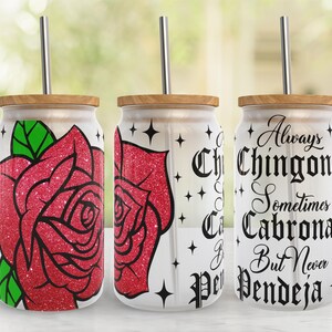 May include: Three stainless steel tumblers with lids and straws. The tumblers have a white background with a red glitter rose design on the left tumbler and black text on the right tumbler that reads "Always Chingona Sometimes Cabrona But Never Pendeja".