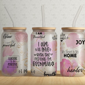 Può includere: Tre bicchieri di vetro smerigliato con citazioni motivazionali e disegni ad acquerello. Le citazioni sono "Glow I am powerful I choose to be positive", "I am beautiful I am in love with the person I'm becoming Just breath", e "Am loveable I radiate joy My heart is my home I am my healer".