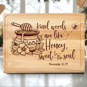 May include: A rectangular wooden cutting board with a carved design. The design includes a honey pot with a honey dipper, a flower, and the text "kind words are like Honey, sweet to the soul" from Proverbs 16:24. A bee is also included.