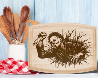 May include: A light-colored wooden cutting board with a carved image of a horror movie character holding a knife. The character is breaking through a wall. The board has a rounded rectangular shape.