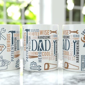 May include: Three white ceramic mugs with the word "DAD" and related words like "wise", "hero", and "mentor" printed on them. The mugs also feature tools and a gear design, perfect for Father's Day.