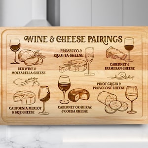 May include: A rectangular wooden cutting board with the words "WINE & CHEESE PAIRINGS" engraved on it. The board features illustrations of wine glasses, cheese, and text indicating wine and cheese pairings, such as "Cabernet & Parmesan Cheese."