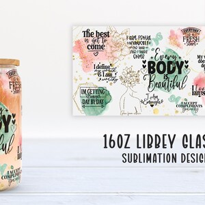 May include: A clear glass Libbey can with a bamboo lid and a stainless steel straw. The glass is decorated with the words "Every Body is Beautiful" and other inspirational phrases in black and gold. A matching design is on a white background.