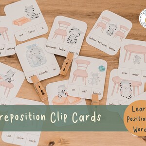 May include: A set of preposition clip cards featuring illustrations of cats, mice, and furniture. The cards have words like "behind", "in front of", "among", "out", "below", "in", "between", "next to", "inside", "outside", "on", "over", "under", and "inside".