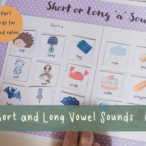 May include: A printable educational game for kids to learn short and long vowel sounds. The game features colorful illustrations of objects with words like "nap", "lamp", "tag", "rain", "snail", "cat", "sat", "crab", "cake", "crayon", "bat", and "tack".