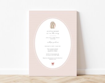 May include: A pink and white baby shower invitation with a cute bunny illustration. The invitation reads "A little bunny is on the way" and includes the date, time, and location of the shower. It also includes the name of the honoree, "Noelyn Jenkins".