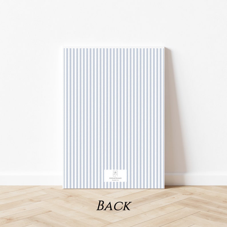 Op de afbeelding: De achterkant van een witte kaart met blauwe verticale strepen. De kaart heeft een klein logo rechtsonder dat "Annagrams" en "Bedankt" zegt.