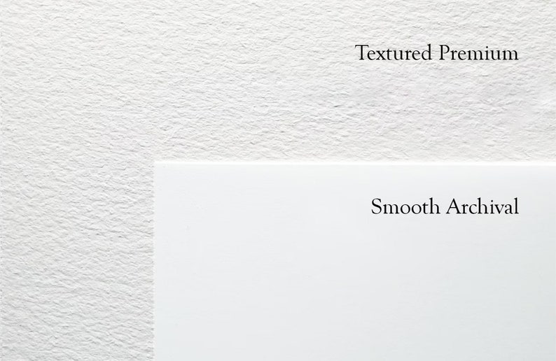 Op de afbeelding: Close-up van twee witte oppervlakken, een met textuur en het label "Textured Premium" en de andere glad en met het label "Smooth Archival".