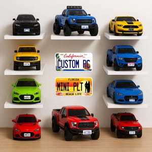 Op de afbeelding: Een verzameling speelgoedauto's in verschillende kleuren, waaronder zwart, blauw, geel, groen en rood, tentoongesteld op witte planken. De collectie bevat een blauwe pick-up truck, een gele sportwagen en een rode sportwagen. Er worden ook twee kentekenplaten weergegeven.