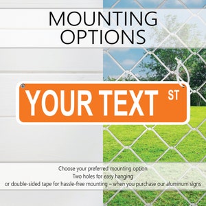 Puede incluir: Se&ntilde;al de metal naranja con texto blanco que dice "YOUR TEXT ST". La se&ntilde;al tiene dos agujeros para colgar y se muestra montada en una valla de madera blanca y una valla de cadena.