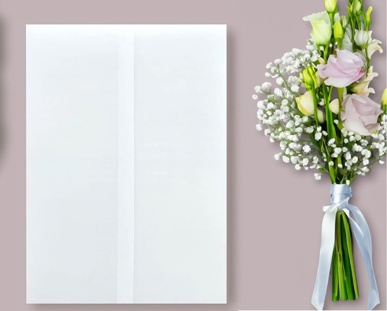 Pu&ograve; includere: Una busta bianca con una piega verticale al centro, accanto a un mazzo di fiori bianchi e rosa legati con un nastro blu chiaro.