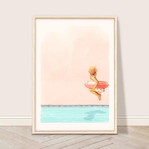 Peut inclure: Une impression d'art encadrée représente un enfant en maillot de bain à pois, sur le point de sauter dans une piscine. L'enfant tient un anneau gonflable rose et blanc. L'eau de la piscine est bleu clair et le fond est de couleur pêche.