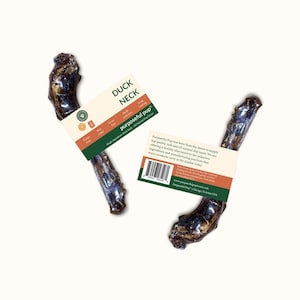 May include: Two duck necks with attached product labels. The labels read "Duck Neck" and "purposeful pup". The duck necks are brown and dark in color. The labels are white with green and orange accents.