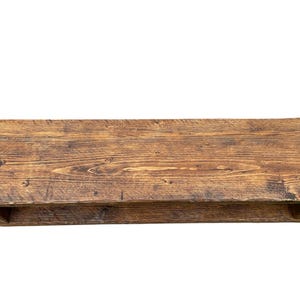Puede incluir: Estanter&iacute;a rectangular de madera r&uacute;stica con acabado natural envejecido. La estanter&iacute;a es de color marr&oacute;n c&aacute;lido, con vetas y nudos de madera visibles. Cuenta con una balda inferior para almacenamiento adicional. Ideal para exhibir objetos.