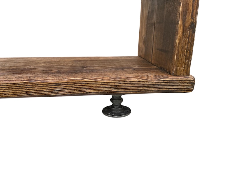 Puede incluir: Estanter&iacute;a r&uacute;stica de madera con acabado marr&oacute;n oscuro. Se apoya en una base de metal negro con conexiones de tuber&iacute;a. La veta de la madera es visible, lo que a&ntilde;ade a la est&eacute;tica natural. La estanter&iacute;a est&aacute; dise&ntilde;ada para montaje en pared.