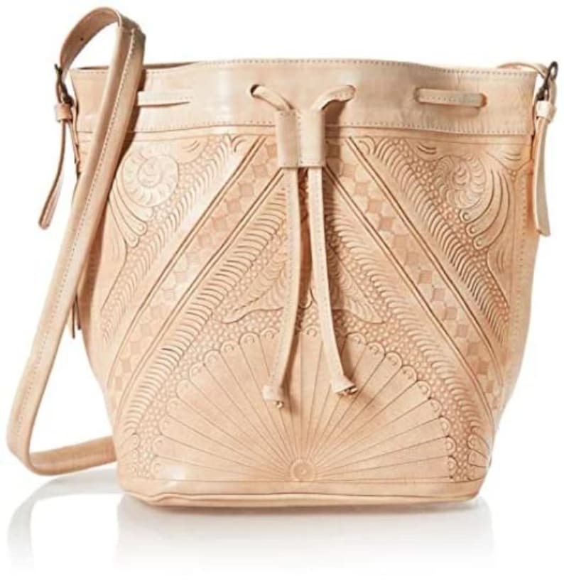 May include: A light brown leather bucket bag with a drawstring closure and a long shoulder strap. The bag has intricate embossed floral patterns.