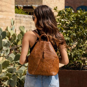 brown faux leather backpack with ivory floral crochet overlay The Sak Sayulita - Hand this bag is ready to carry all of your essentials Handknitted Raffia Backpack, Crochet Straw