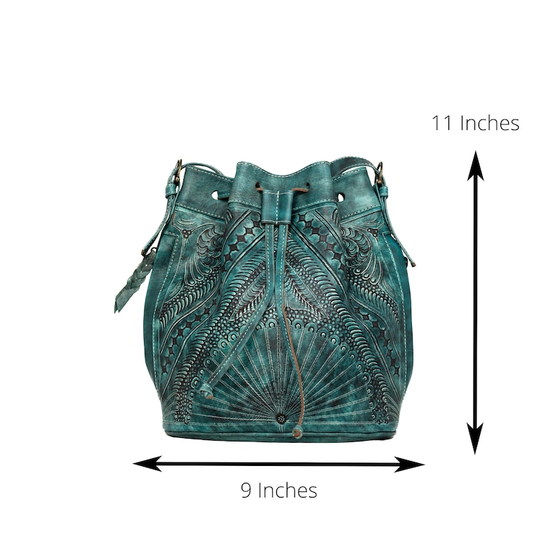 May include: Teal blue leather bucket bag with intricate floral and star-shaped embossed designs. The bag measures 11 inches tall and 9 inches wide.