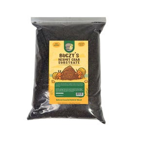 May include: A clear plastic bag filled with dark substrate, labeled "Bugzy's Hermit Crab Substrate." The label features illustrations of hermit crabs and a mound of substrate. The bag is sealed and ready for use.