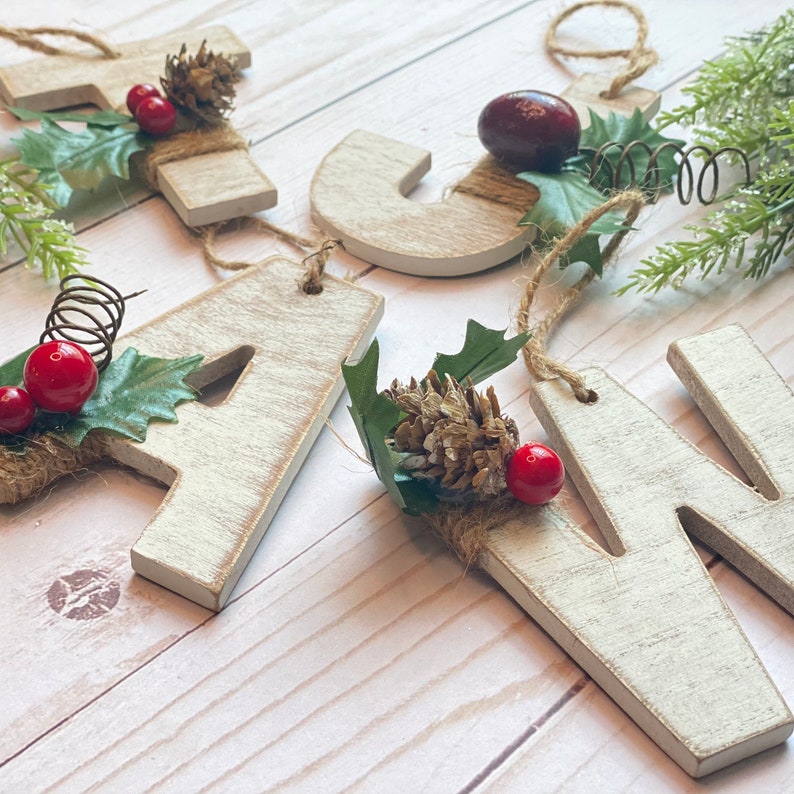 White washed distressed wood letter Christmas ornament with floral.