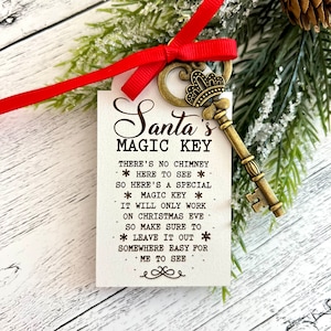 May include: A white card with the text "Santa's Magic Key" and instructions for leaving the key out for Santa on Christmas Eve. A gold-colored key with a crown is attached to the card with a red ribbon.