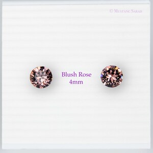 May include: Two blush rose-colored, 4mm round gemstones on a white background. The gemstones are faceted, reflecting light. Text on the image reads "Blush Rose 4mm". The brand name "Mustang Sarah" is in the top right corner.