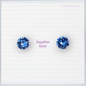 May include: Two round, faceted, sapphire blue gemstones, each 4mm in diameter, are displayed on a white background. The word "Sapphire" and the measurement "4mm" are printed in a purple font between the gemstones.