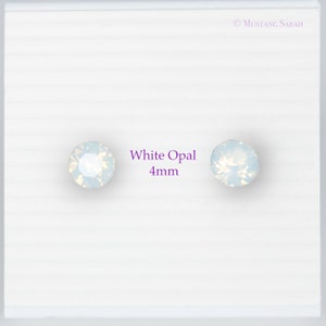May include: Two white opal stud earrings, each 4mm in diameter, are displayed on a white background. The earrings have a round shape and a shimmering, iridescent appearance. The text "White Opal 4mm" is next to the earrings.