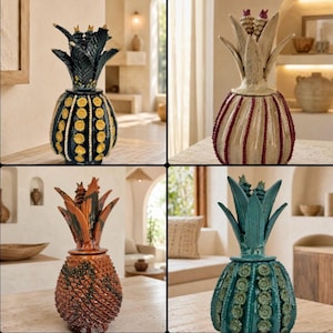 Op de afbeelding: Vier decoratieve keramische potten in de vorm van een ananas met deksels. Eén is zwart met gele accenten, één is crème met rode verticale lijnen, één is bruin met een textuur en één is groenblauw met groene cirkelvormige patronen.